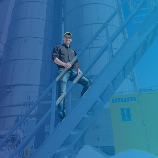 A male employee at a Saint-Gobain North America plant smiles, excited to start his manufacturing internship
