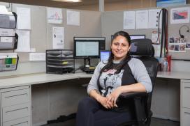 A woman poses at her desk