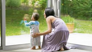 Woman with infant looking through a glass window